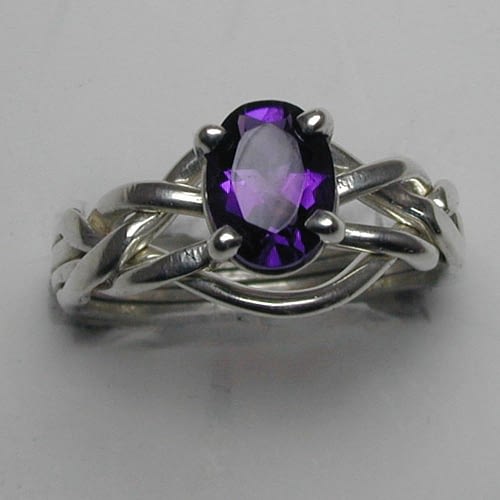 A four band puzzle ring with an amethyst stone